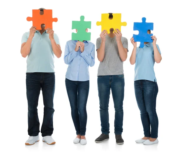 Mensen die betrekking hebben op gezicht met puzzelstukjes — Stockfoto