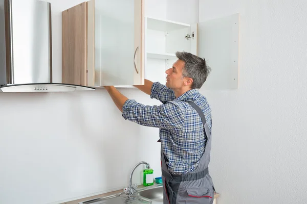 Serviceman Fixing Cabinet With Screwdriver In Kitchen — Stock Photo, Image