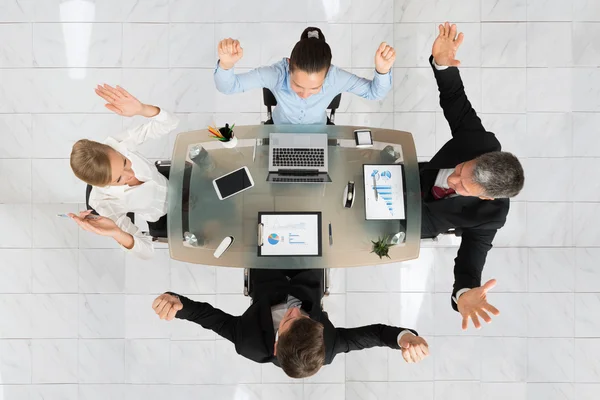 Aufgeregte Geschäftsleute sitzen am Schreibtisch — Stockfoto