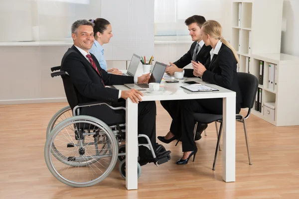 Homme d'affaires handicapé avec ses collègues au bureau — Photo