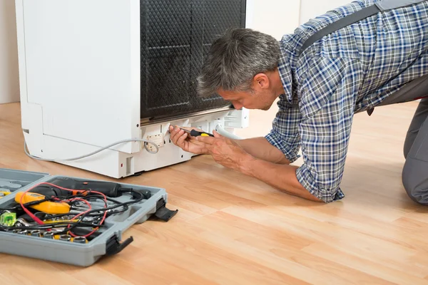 Reparador Reparação Máquina de lavar louça com chave de fenda — Fotografia de Stock