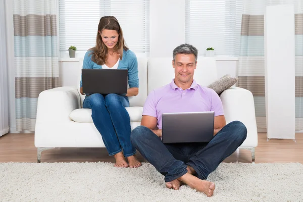 Pareja usando computadoras portátiles — Foto de Stock