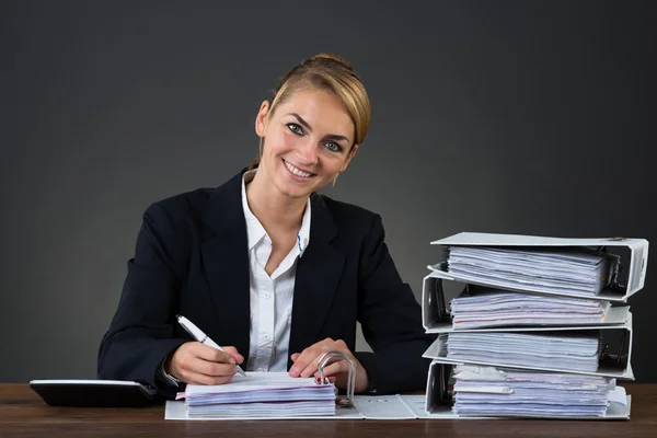 Geschäftsfrau schreibt am Schreibtisch an Dokument — Stockfoto