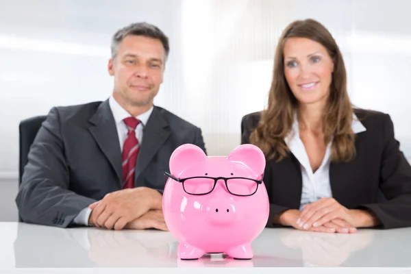 Dos empresarios mirando a Piggybank — Foto de Stock