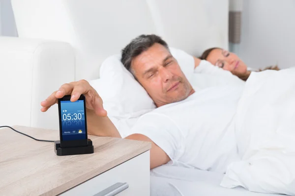 Man On Bed Snoozing Alarm Clock — Stock Photo, Image