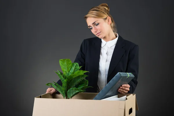 Traurige Geschäftsfrau packt ihre Sachen am Schreibtisch — Stockfoto