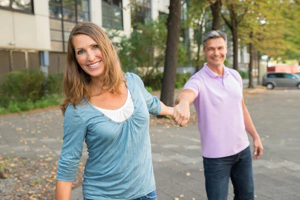 Uomo tirando donna in il strada — Foto Stock