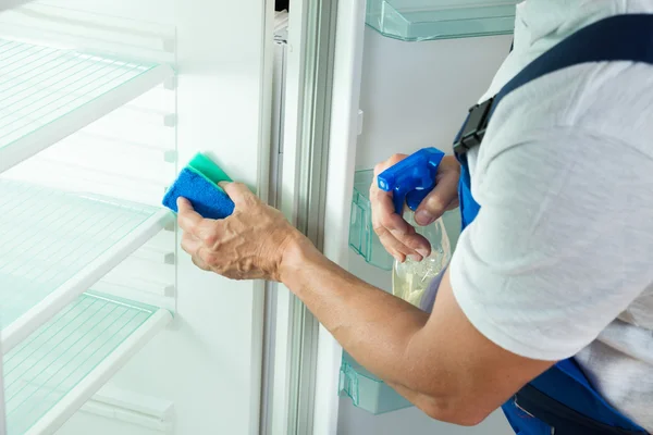 Janitor Cleaning Refrigerator At Home — Stock Photo, Image