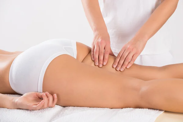 Cliente feminino recebendo massagem na perna — Fotografia de Stock
