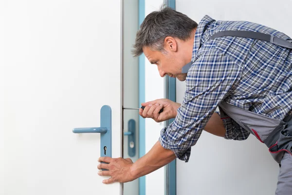 Teknikern fastställande lås i dörren med skruvmejsel — Stockfoto