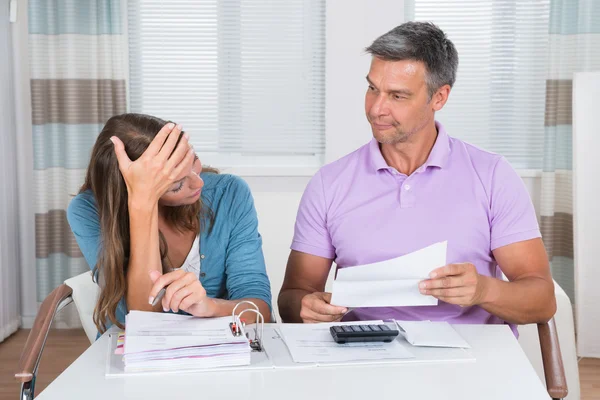 Bezorgd paar kijken naar onbetaalde facturen — Stockfoto