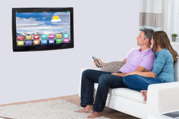 Couple Sitting On Sofa Watching Television — Stock Photo, Image