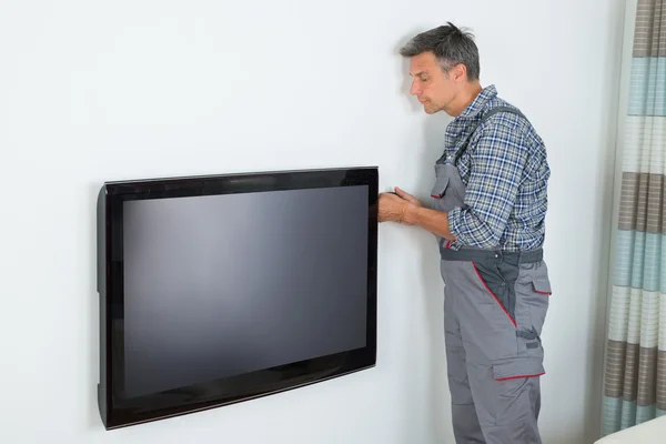 Técnico instalando televisão em casa — Fotografia de Stock