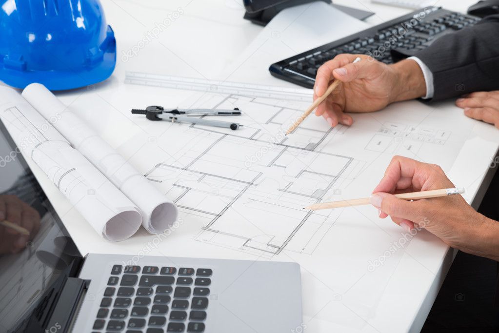 Two Architects Working On Blueprint