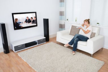 TV izlerken kanepede otururken kadın