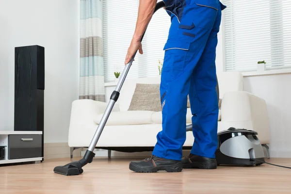 Hausmeister reinigt Boden mit Staubsauger — Stockfoto