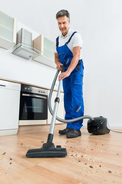 Hausmeister reinigt Boden mit Staubsauger — Stockfoto