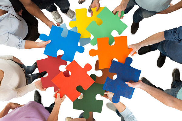 People Holding Colorful Puzzle Pieces