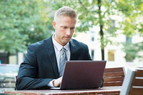 Jeune homme d'affaires travaillant sur ordinateur portable — Photo