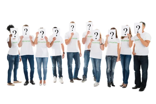 Dobrovolníci pokrývající tváře otázku zvěrokruhu — Stock fotografie