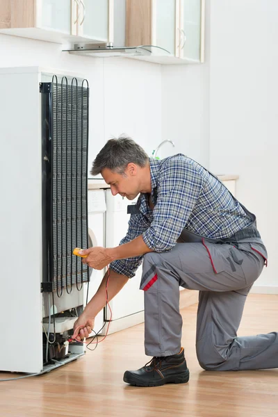 Teknikern kontrollera kylskåp med Multimeter hemma — Stockfoto