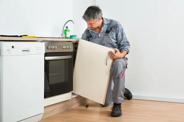 Klusjesman vaststelling wastafel deur In keuken — Stockfoto