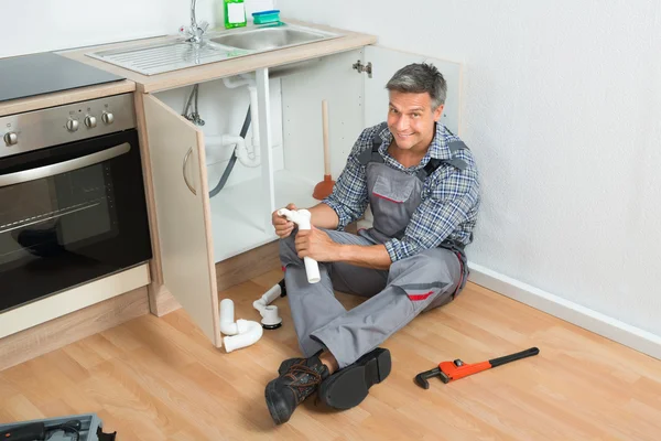 Plumber Repairing Sink Pipe In Kitchen — Stock Photo, Image