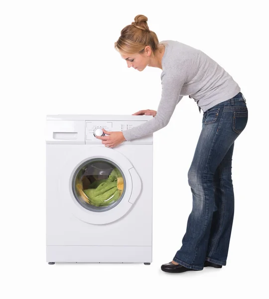 Женщина с помощью стиральной машины — стоковое фото