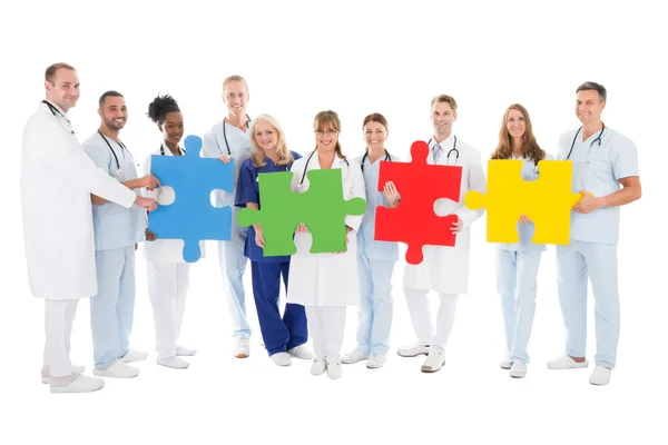 Ärzteteam hält Puzzleteile — Stockfoto