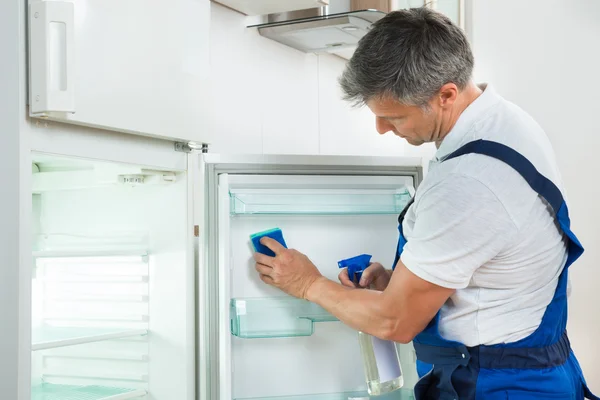 Vaktmästare städa kylskåpet hemma — Stockfoto