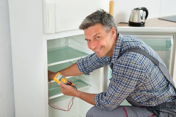 Verificando o refrigerador com multímetro digital — Fotografia de Stock