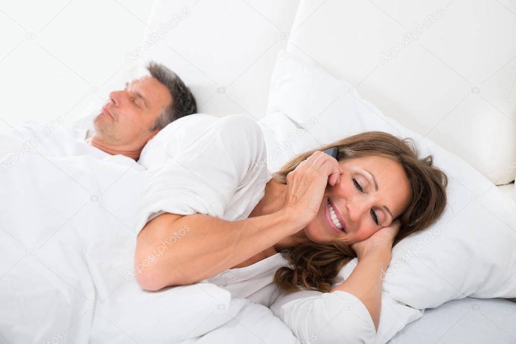 Woman Busy On Phone While Man Sleeping