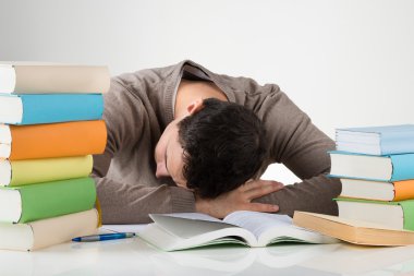 Öğrenimleri sırasında masasına yaslanmış yorgun öğrenci