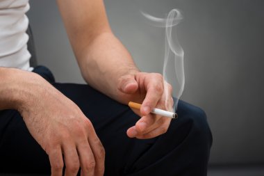 Midsection Of Man Holding Cigarette clipart
