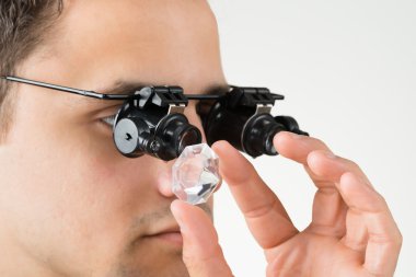 Elmas büyüteç ile inceleyerek kuyumcu