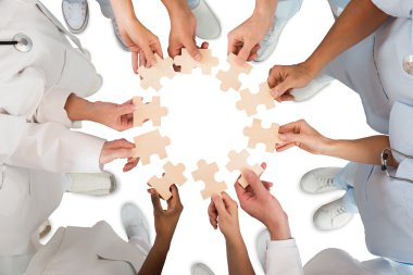 Medical Team Holding Jigsaw Pieces clipart
