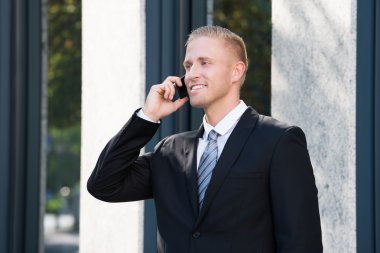 İş adamı cep telefonuyla konuşuyor.