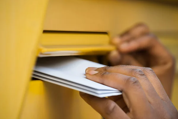 La mano de la persona insertando cartas en el buzón — Foto de Stock