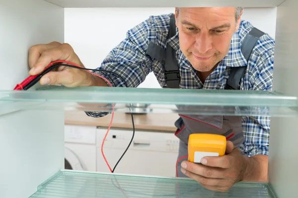 Reparateur controleren koelkast met Digitale Multimeter — Stockfoto