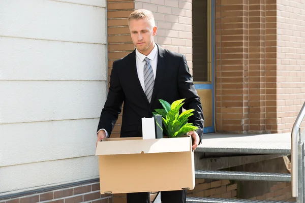 Homme d'affaires debout avec boîte — Photo