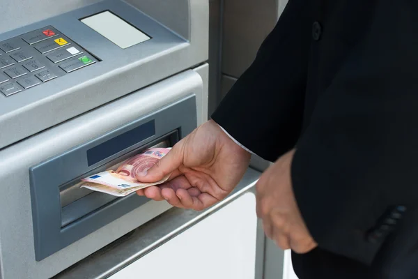 Person hebt Geld am Geldautomaten ab — Stockfoto