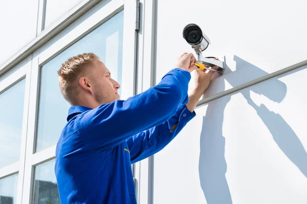 Técnico de fijación de la cámara en la pared — Foto de Stock