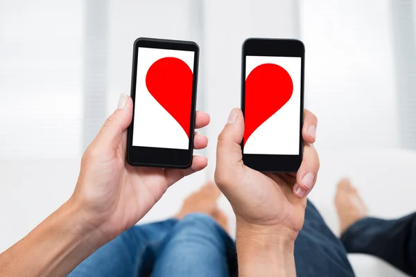 Deux personnes avec des téléphones mobiles — Photo