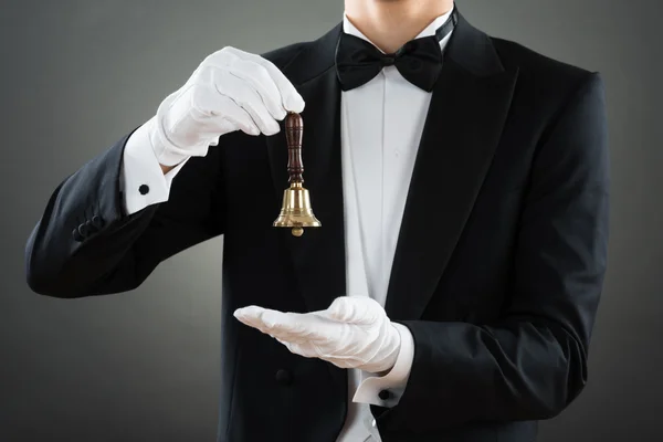 Midsection del camarero que sostiene la campana del anillo —  Fotos de Stock