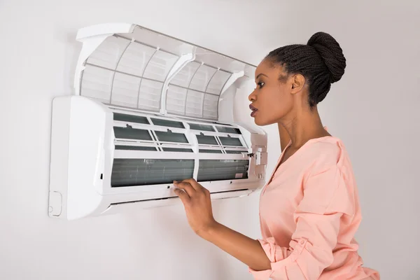 Vrouw controleren airconditioner — Stockfoto