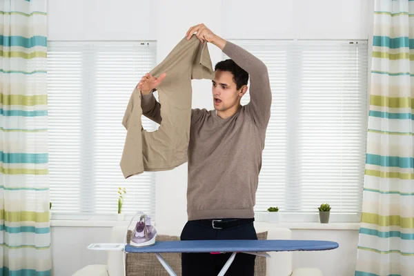 Man tittar på järn brända Tshirt — Stockfoto