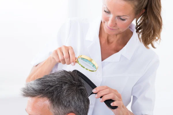 Dermatologista olhando para o cabelo do paciente — Fotografia de Stock
