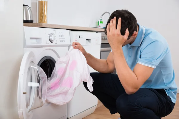 Spända Man håller smutsiga Tshirt — Stockfoto