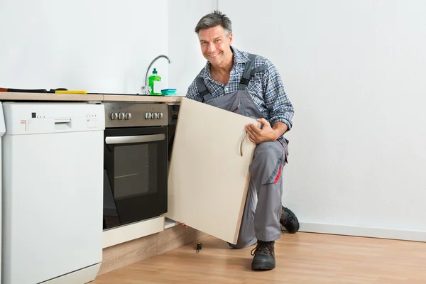 Handyman fixação pia porta na cozinha — Fotografia de Stock