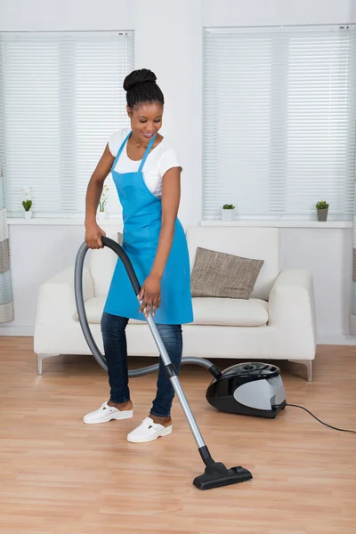 Kvinnan städa golvet med dammsugare — Stockfoto